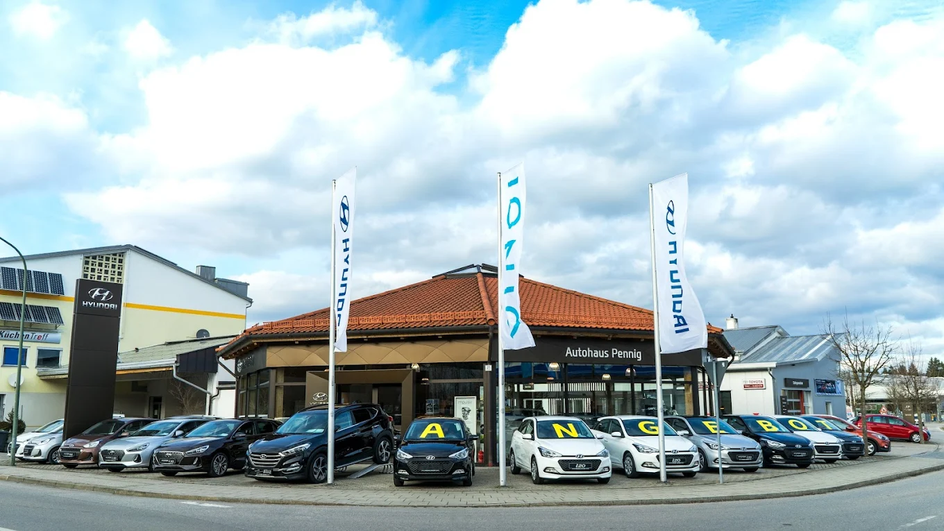 Autohaus Pennig in Geretsried mit Hyundai Fahrzeugen und Fahnen vor dem Showroom